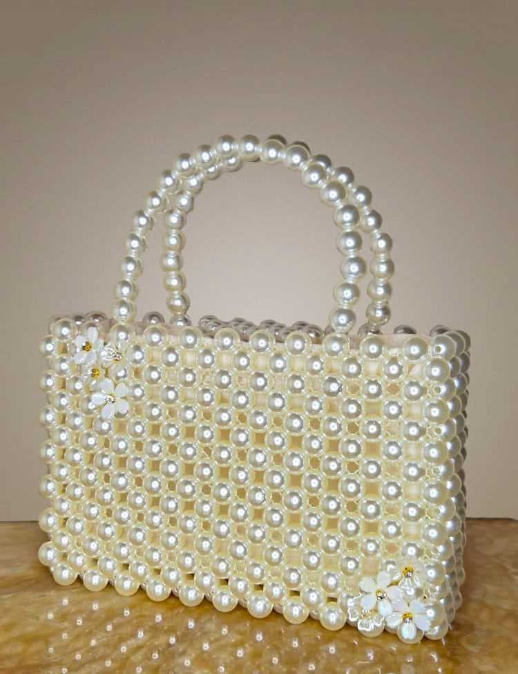 an elegant and luxurious handbag, fully crafted from shiny white pearl